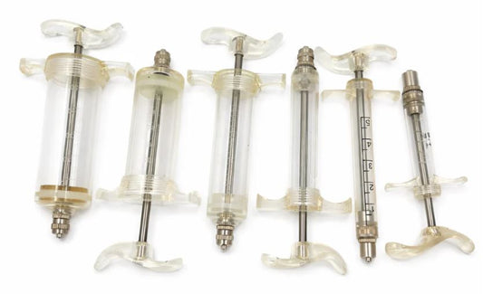 Set of six medical syringes with different capacities on a white background